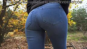 Ερασιτέχνης κορίτσι 18+ σε σφιχτά μπλε τζιν δείχνει τον μεγάλο κώλο της στο δάσος για διασκέδαση.