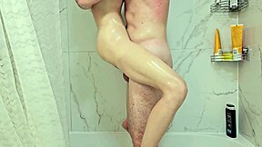 בחורה קטנה שחומה צעירה גונחת בקול בזמן שמרטיבה את הגוף הצר שלה במקלחת