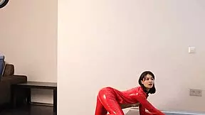 Young brunette in red latex exposes shaved pussy