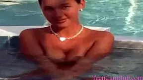 A model teases with big tits by the pool in a bikini.
