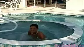 A model teases with big tits by the pool in a bikini.