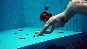 Dashka enjoys a beautiful swim in the pool, showcasing her brunette hair and nude body