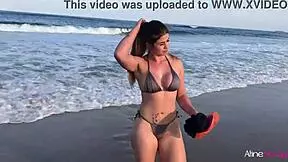 Blonde girl bangs her fan on the beach