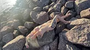 This hot exhibitionist is playing with her clit right on the public beach.