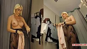 An amateur blonde tries on sexy clothes in a public dressing room, captured on hidden cam