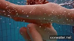 Milana and Katrin tease each other by ripping bikinis off in the pool. They swim nude underwater in softcore fun.