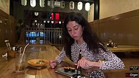 a girl eats sushi rolls in a bar