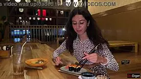 a girl eats sushi rolls in a bar