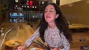 a girl eats sushi rolls in a bar