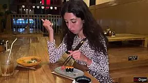 a girl eats sushi rolls in a bar
