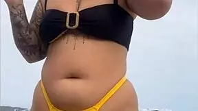 young african girl wears tight yellow bikini splitting swollen pussy to attract attention on usa beach