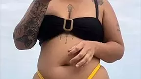young african girl wears tight yellow bikini splitting swollen pussy to attract attention on usa beach