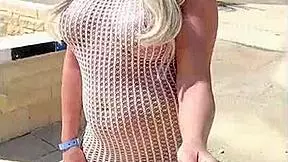 Blonde exhibitionist flashes big tits and ass in transparent dress outdoors without underwear