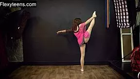 teen russian gymnast stretches flexibly in the gym