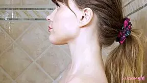 Charming blonde girl enjoys a hot shower