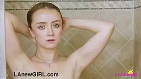 Cute blonde teen steps into shower for steamy solo tease.