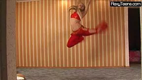 Sexy Russian belly dancer stretches flexible body teasing in red gym dress