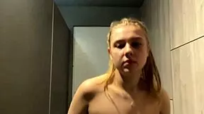 A young woman pleasures herself alone in the gym during a quiet moment after workout, seeking private release.