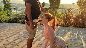 Redhead gets caught on outdoor patio during intense public encounter at sunset