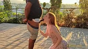 Redhead gets caught on outdoor patio during intense public encounter at sunset