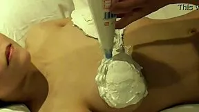 hey girlfriend, watch this big-titted japanese beauty cover her boobs in whipped cream then lick it all off close-up in bed.