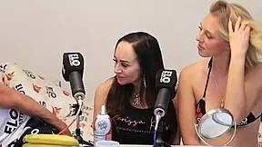 blonde and brunette share banana topped with cream in playful licking scene