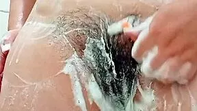 this young latina brunette shaves her hairy pussy close up in the bathroom