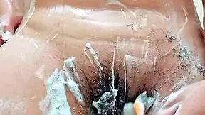 this young latina brunette shaves her hairy pussy close up in the bathroom