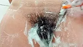 this young latina brunette shaves her hairy pussy close up in the bathroom
